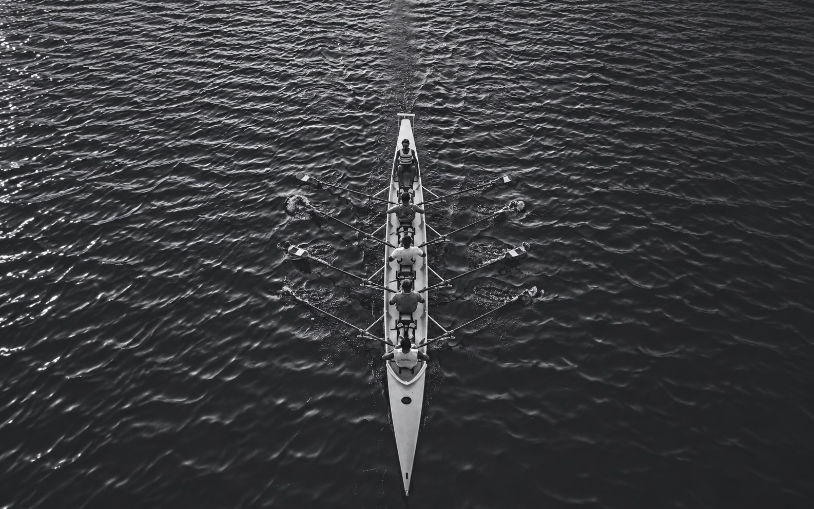Illustrative AI-adapted overhead photograph of a rowing team working together.
