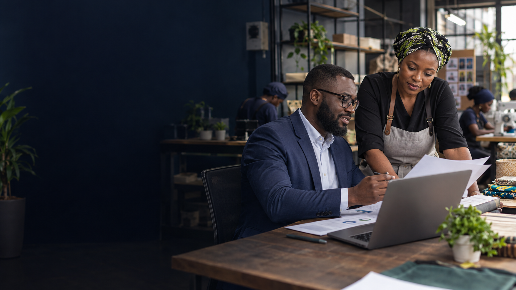 A Nigerian business owner reviewing a growth plan with an adviser.